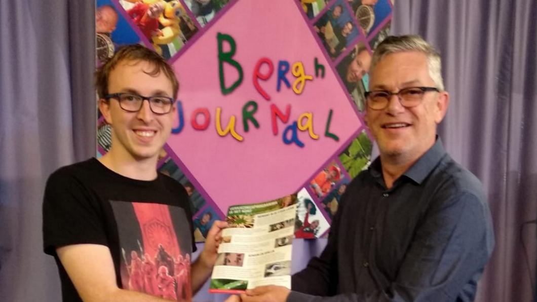 Bryan (l) van het Berghjournaal ontvangt het eenvoudig geschreven verkiezingsprogramma van GroenLinks uit handen van Louis Koppel (r). GroenLinks Noordwijk De Zilk Noordwijkerhout verkiezingen