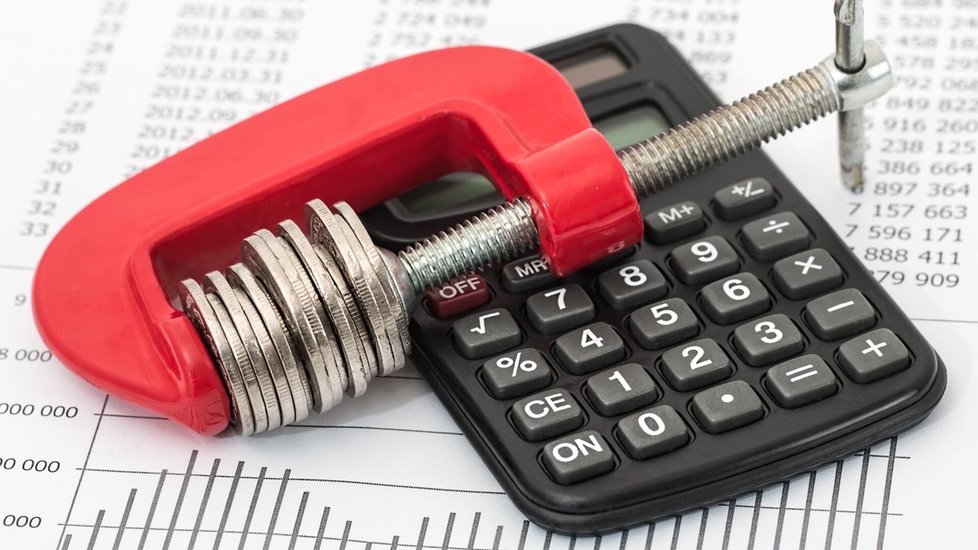 Geld in een bankschroef naast een calculator